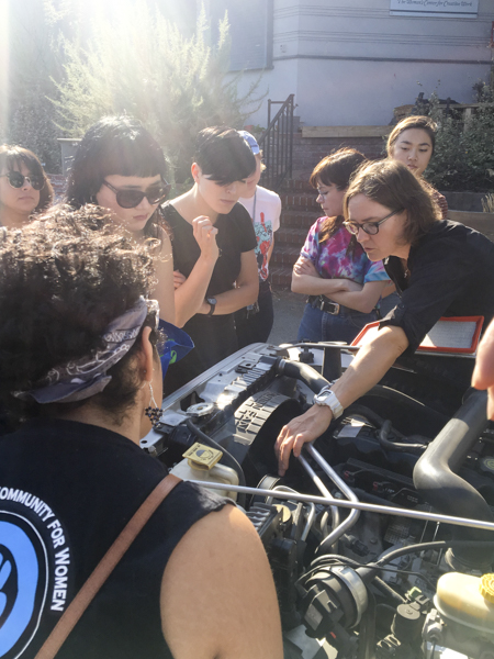 photo of instructor pointing out engine parts to a group